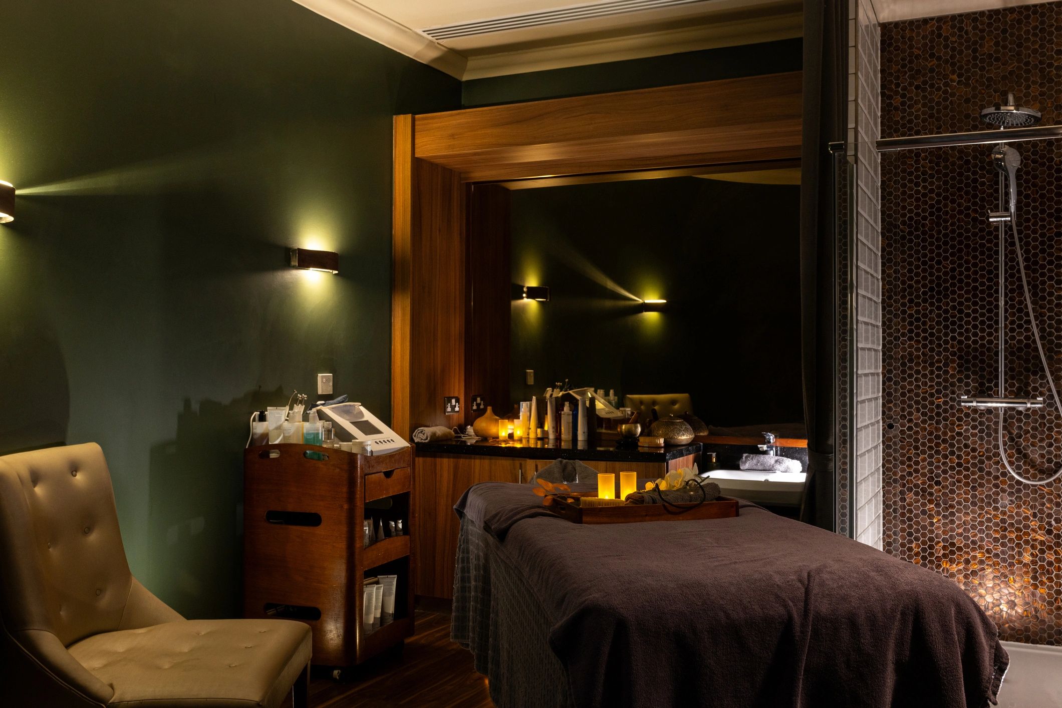 Warm, serene treatment room with massage bed and soft lighting