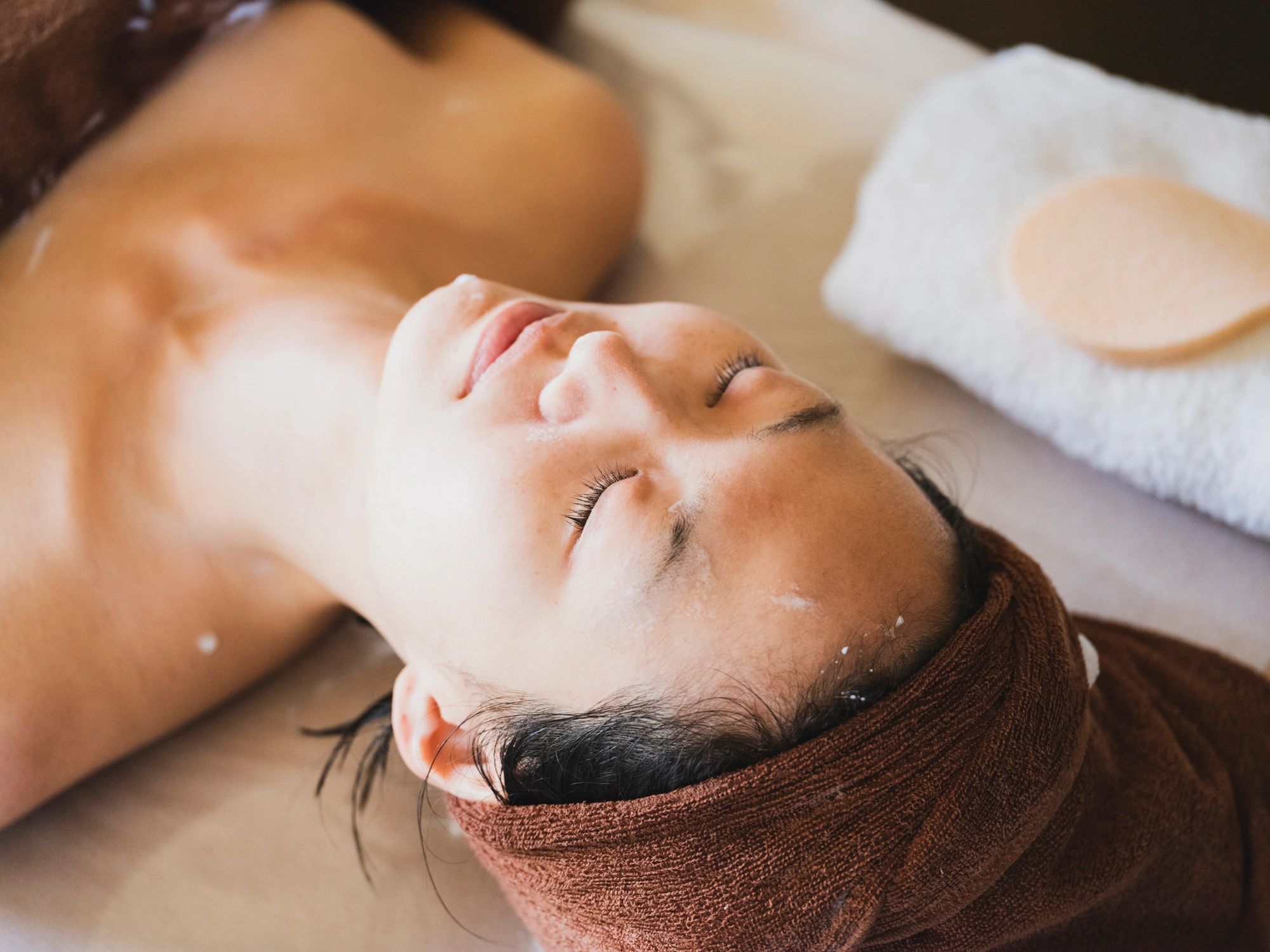 Client receiving a relaxing facial treatment in a spa setting